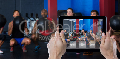 Composite image of cropped hand holding digital tablet