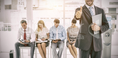 Businessman gesturing thumbs up against people waiting for interview