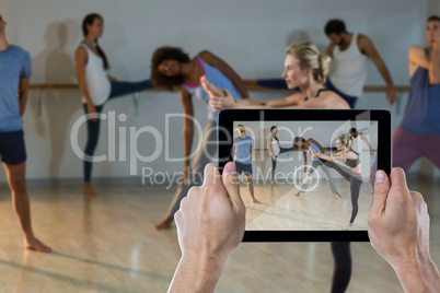 Composite image of cropped hand holding digital tablet