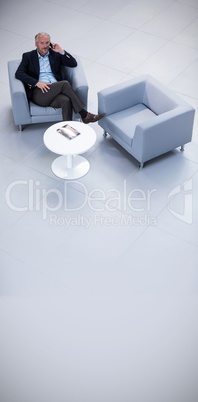 Businessman sitting on chair and talking on mobile phone