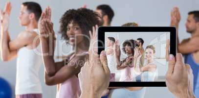 Composite image of cropped hand holding digital tablet