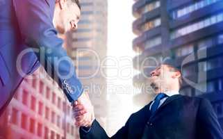 Composite image of happy business people shaking hands