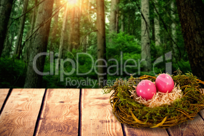 Composite image of pink easter eggs on artificial nest