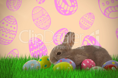 Composite image of brown bunny with colorful easter egg