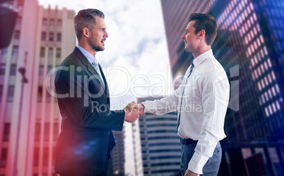 Composite image of smiling businessmen shaking hands