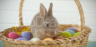 Colorful Easter eggs and Easter bunny in wicker basket