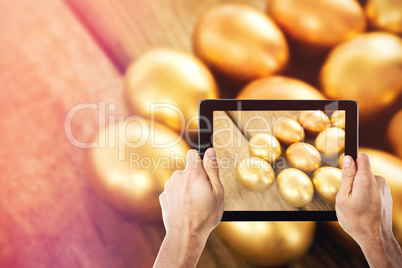 Composite image of cropped hand holding digital tablet