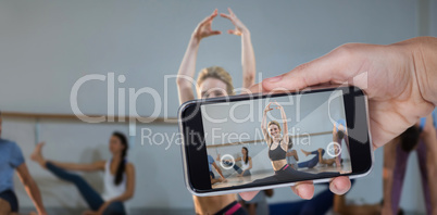 Composite image of hand holding mobile phone against white background