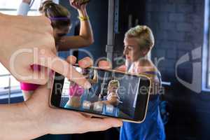Composite image of female trainer instructing woman in gym
