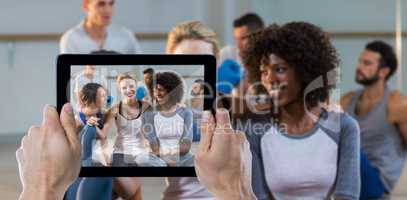 Composite image of cropped hand holding digital tablet