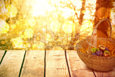 Composite image of easter eggs in paper nest basket