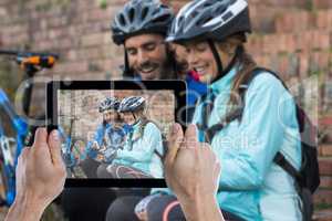 Composite image of cropped hand holding digital tablet