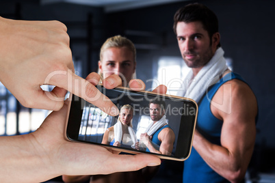 Composite image of portrait of serious friends with towel in gym