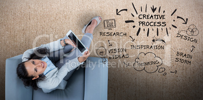 Composite image of woman on her tablet looking up