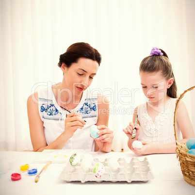 Mother and daughter painting easter eggs