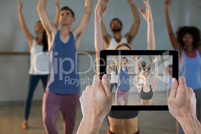 Composite image of cropped hand holding digital tablet