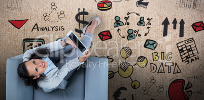 Composite image of woman on her tablet looking up