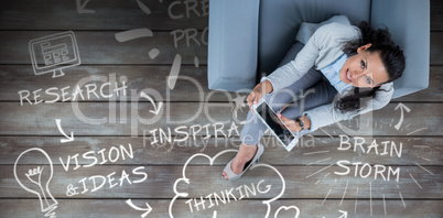 Composite image of woman on her tablet looking up