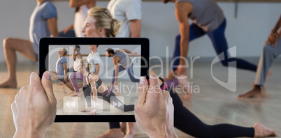 Composite image of cropped hand holding digital tablet