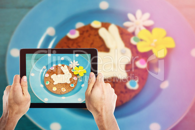 Composite image of cropped hand holding digital tablet