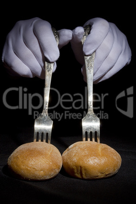 Buns on the forks and hands in white gloves