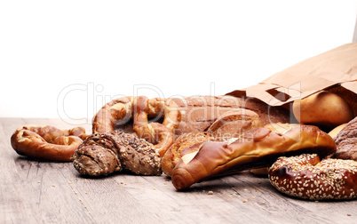 Different kinds of bread and bread rolls on board from above. Ki