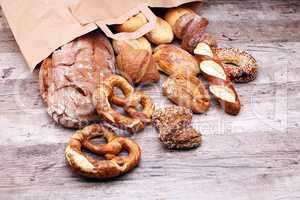 Different kinds of bread and bread rolls on board from above. Ki