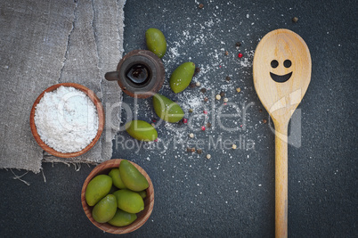 Green olives and salt in wooden bowls