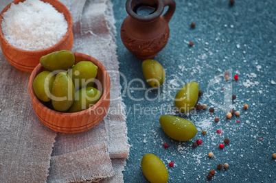 Green olives and olive oil in a clay pitcher