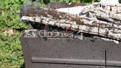 Firewood burning in metal broiling tray