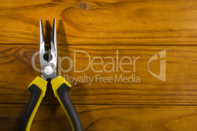 multitool pliers on wooden background