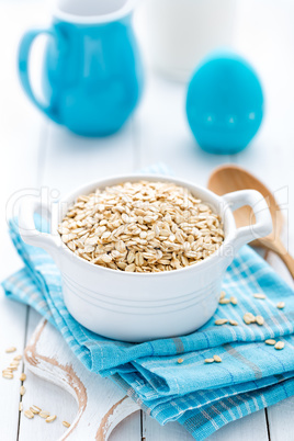 Rolled oats on white wooden background
