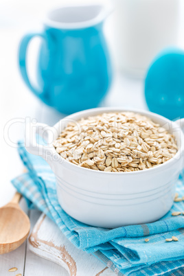 Rolled oats on white wooden background