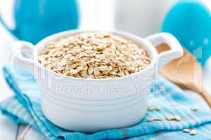 Rolled oats on white wooden background