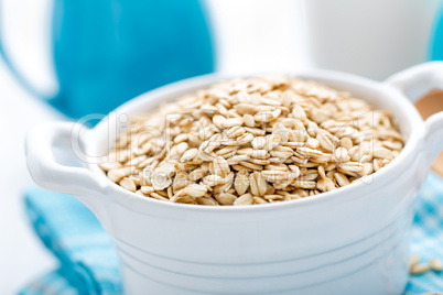 Rolled oats on white wooden background