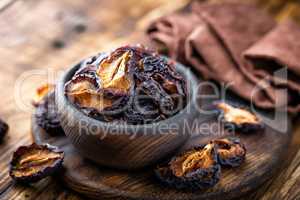 Prune, dried plums fruits on dark rustic wooden background
