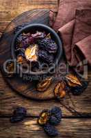 Prune, dried plums fruits on dark rustic wooden background