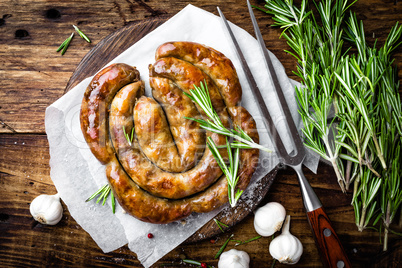 Grilled sausage on dark rustic wooden background, top view
