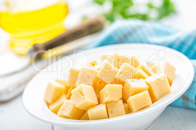 Cheese slices on plate, white background