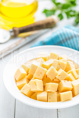 Cheese slices on plate, white background