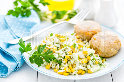 Vegetable cabbage salad and meatballs on plate close up, white background