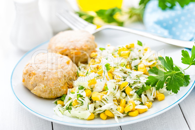 Vegetable cabbage salad and meatballs on plate close up, white background