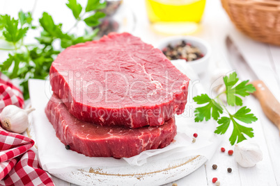 Raw, uncooked beef meat steaks on white wooden background