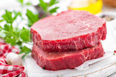 Raw, uncooked beef meat steaks on white wooden background