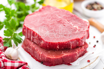 Raw, uncooked beef meat steaks on white wooden background