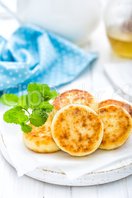 Cottage cheese fritters on white wooden background closeup
