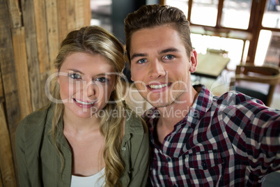 Portrait of smiling couple posing in coffee shop