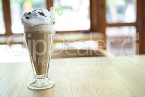 Glass of chocolate milkshake with cream