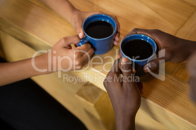 Couple hands holding coffee cups at table