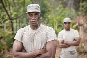 Military soldiers standing with arms crossed during obstacle course